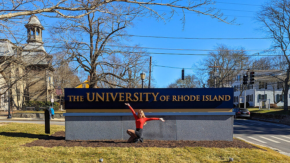 Adelina Herbst vor dem Logo der University of Rhode Island