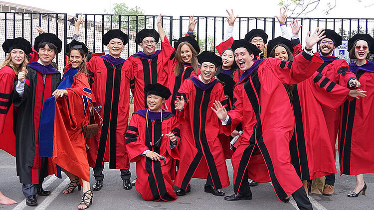 USA Gruppenbild Studierende in roten Abschluss-Roben
